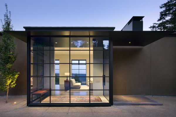 The formal entry sits outside of the private geometry of the house and within the courtyard. Using the same ceiling and floor surfaces on the outside and inside creates a place to welcome guests while still clearly separating the public space from the private home. Steel windows and stucco are elements used throughout the design.