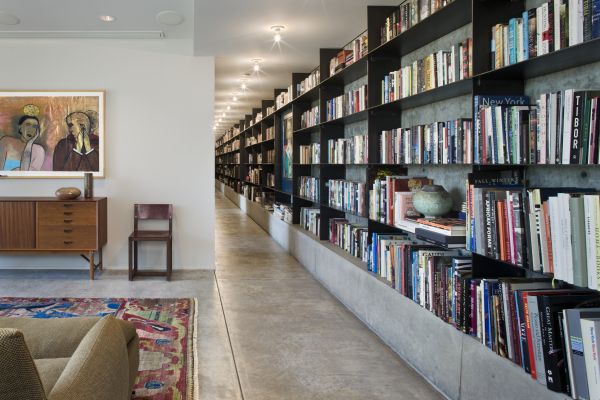 Cutting through the recreation room and the rest of the first floor, a 100-foot-long library provides shelving for books, display space and a visual spine to the lower level. The library’s construction materials also repeat the steel and concrete used elsewhere throughout the lower level.