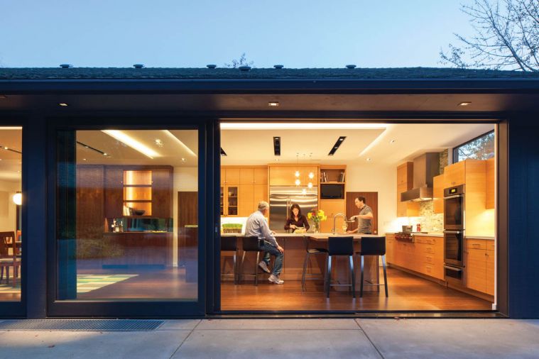 The view from the patio through the floor-to-ceiling sliding glass doors to the kitchen and dining room beyond show how cleverly Engelhard-Jones redesigned the space. The dining room was relocated from the front of the house so it would be adjacent to the kitchen and the patio. This is particularly convenient when the couple entertains large groups such as fundraising parties and family events. “People can now easily move through the space,” she says, “eating, visiting, relaxing.”