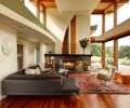 The curve of the dropped ceiling over the corridor mimics the curve on the fireplace wall. Both soften the straight lines of the windows and framing, the sharp angles of the roofline, and the structured furnishings. Besides the view, the fireplace is a beautiful part of the room. It is finished with anigre wood and a porcelain tile stained to look like brushed metal. The rug, purchased from Tufenkian Carpets, is the one traditional touch in the space.