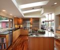 The kitchen is a large room, with plenty of space for guests to relax while the couple cooks. The rich finishes includes beautiful granite on the island, which Marilyn likens to the “galaxy” because of its stellar swirls and Tiger wood on the floor. The green and clear glass tiling in the black splash continues that one accent color from the living and dining rooms. The upper cabinets are finished in figured anigre veneer, while the bottom cabinets feature straight anigre veneer.