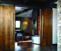 Concrete floors with wood inserts transition into full wood floors in the downstairs study located adjoining the music area and behind the living room. Barn-style sliding doors with hand-hewn hardware can be left open to let the room join the rest of the downstairs or be closed to ensure quiet and privacy.