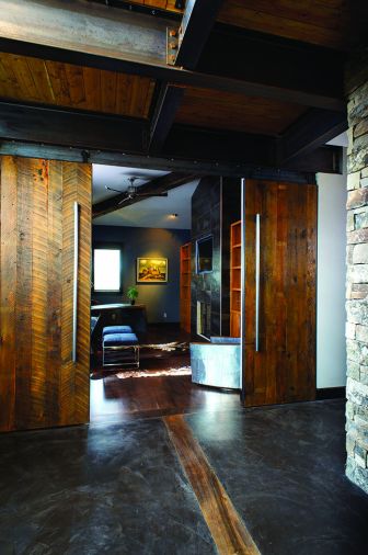 Concrete floors with wood inserts transition into full wood floors in the downstairs study located adjoining the music area and behind the living room. Barn-style sliding doors with hand-hewn hardware can be left open to let the room join the rest of the downstairs or be closed to ensure quiet and privacy.