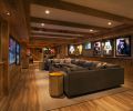 Rough sawn oak walls feature basketball memorabilia in the basement. Spacious seating, and multiple TV screens promote casual entertaining. Highly resistant porcelain plank flooring resembles wood.