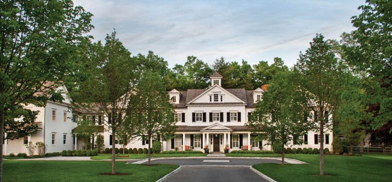 A lengthy front porch unifies the newly renovated Sechan home with such traditional Colonial design elements as cedar shingle gabled roof, dormers, double hung windows, and painted black louver shutters.