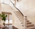 Boxed panels line the entry walls, where horizontal artwork is softened by a fiddle leaf plant. A Bernhardt bench shines beneath the Lillian August lantern.