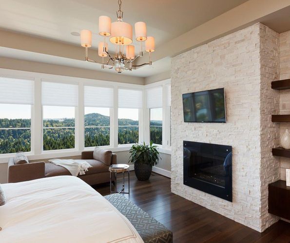 The master suite, warmed by a fireplace clad in white Cronin Stone, features both bed and day bed from Bedford Brown. The bench is upholstered in Kravet fabric and hails from their previous home.