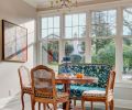 The back wall of the previous kitchen had held cabinets and a lone window. To bring in more light and to accommodate a breakfast area, the cabinetry was removed, the wall was pushed out and a bank of tall windows was added. A Murano glass chandelier – which the homeowners purchased in Venice – now hangs in the new space.