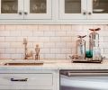 A sink, dishwasher drawers and cabinetry for glassware provide a second prep and bar area near the living areas.