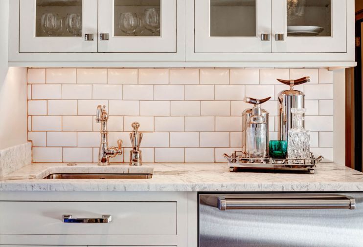 A sink, dishwasher drawers and cabinetry for glassware provide a second prep and bar area near the living areas.