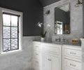 Former upstairs laundry turned master bath features hexagonal marble flooring and Carrera subway tile that acts as a dramatic backdrop for a nickel medicine cabinet and Edison sconces. A single inset sink rests within a 60  Carrera marble countertop.