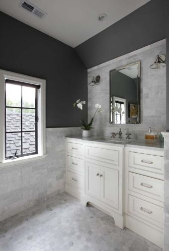 Former upstairs laundry turned master bath features hexagonal marble flooring and Carrera subway tile that acts as a dramatic backdrop for a nickel medicine cabinet and Edison sconces. A single inset sink rests within a 60' Carrera marble countertop. 