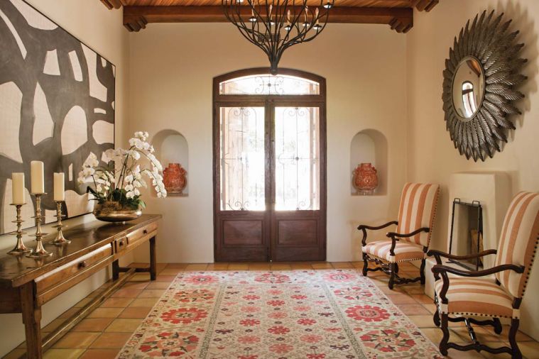 An Ironware International chandelier graces the entry, with “Porter Teleo, Tangled Gris” framed wallcovering and vintage Maitland Smith mirror from 1stDibs®.