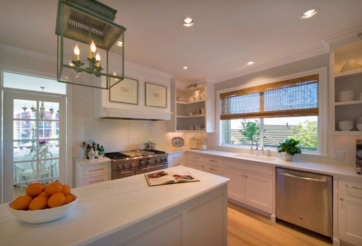 The Calcutta marble-topped island can easily accommodate two chefs. To unify the cabinets and island, designer Heidi Semler painted them the same shade.