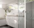 A mirror running the width of the wall above the sinks reflects light into the master bath.