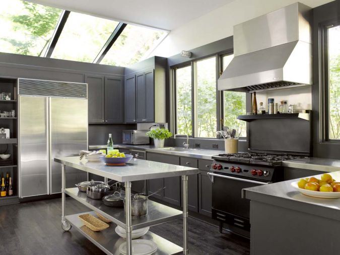 In the kitchen, oak flooring was installed, skylights and windows were replaced and the cabinetry was repainted gray and given new pulls. Stainless steel unites the space.