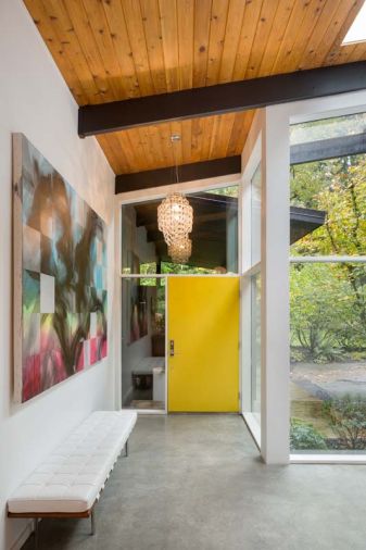 A new expanded entry to the home provides a more hospitable foyer. The bright door and custom bench are harbingers of the design elements inside. The chandelier at the door was originally purchased by the homeowners through Vanillawood for a rental and has moved with the family from house to house ever since. Art is from Portland’s Fourteen30 Contemporary Gallery.