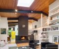 A central fireplace graphically connects the floor to the two-story ceiling and keeps the room to human proportions. The Vanillawood team painted it and the beams black to bring the home’s exterior colors indoors.