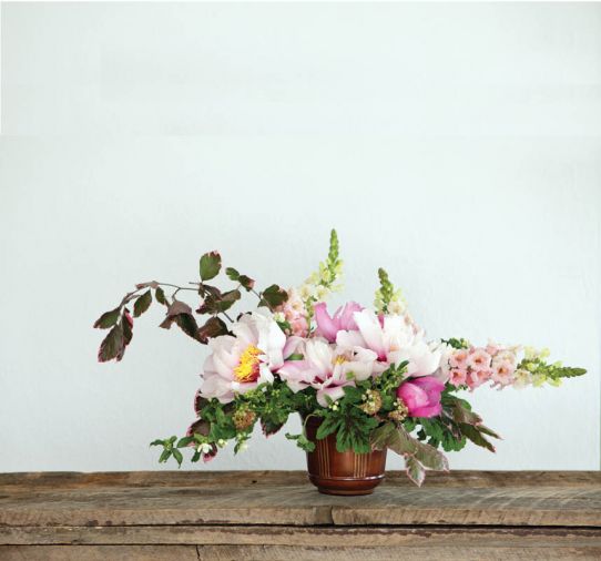 POETIC PEONIES ‘Cora Louise’ peonies steal the show when set against a fresh green backdrop of mock orange and tri color Beech. This sweet arrangement blends lush pink peonies, creamy white snapdragons and earthy stems of geranium and ninebark. Flowers by Kailla Platt, <a href='http://www.kaillaplattflowers.com' target='_blank'>www.kaillaplattflowers.com</a>. Use this stem count to recreate the arrangement: 3 Stems Tri-color Beech, 7 Stems Ninebark foliage & flowers, 3 Stems Mock Orange, 3 Stems Pink Trumpet Snapdragons, 3 Stems Peony ‘First Arriva,l’ 3 Stems Peony ‘Cora Louise,’ 3 Stems Chocolate Mint Scented Geranium.