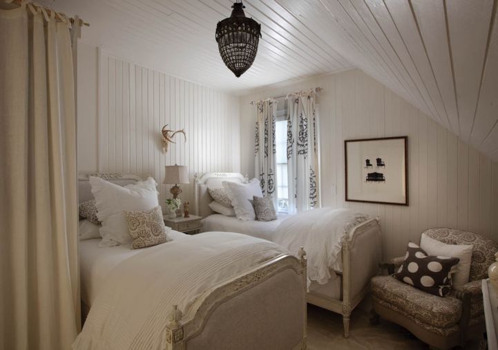 A 1920s American easy chair upholstered in the same Les Indiennes fabric as the occasional pillows gets a bit of pop from a polka-dot pillow by the same manufacturer. The couple changed out all of the lighting in the house, including this reproduction of a French beaded crystal chandelier. Knob and tube wiring is original.