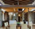 Two extendable walnut Cross tables from Design Within Reach fill the dining area looking toward the kitchen’s butler’s pantry left and owner’s wing at right. “The dominant high ceiling in the living and dining areas worked well, but we dropped the entry and kitchen ceiling to break it up and redirect you toward the screen wall, going left or right,” explains Schouten.