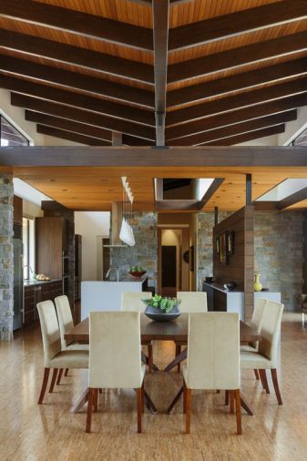 Two extendable walnut Cross tables from Design Within Reach fill the dining area looking toward the kitchen’s butler’s pantry left and owner’s wing at right. “The dominant high ceiling in the living and dining areas worked well, but we dropped the entry and kitchen ceiling to break it up and redirect you toward the screen wall, going left or right,” explains Schouten.