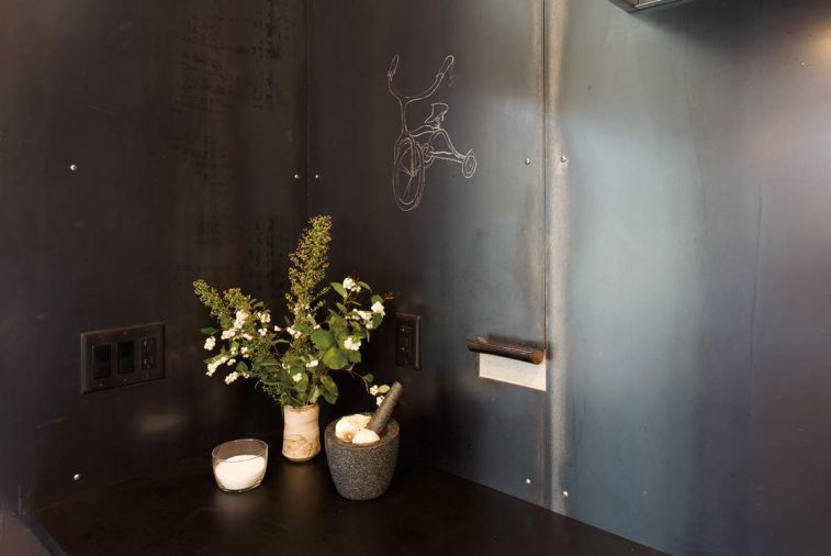 Although the architect’s plan behind the steel wall panels didn’t entirely pan out, they do insert most of the decorative drama in the house. And the soapstone markers are constantly employed—here, for a little tricycle sketch—especially by the many visiting kids.