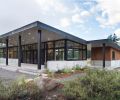 In order to maximize views, better mesh with landscape and grab as much natural light as possible, the architect reduced much of the dwelling to a simple glass box. The home’s windows and sliding glass doors were custom fabricated by Sierra Pacific Windows. The sloped roof allows for normal drainage and retains snow during winter in order to reduce pile-ups around the house and to take advantage of its insulation. The outbuilding, attached only by the veranda’s ceiling, houses the indispensable ski wax room and wood-fired sauna, easily restoked from an adjacent wood box.