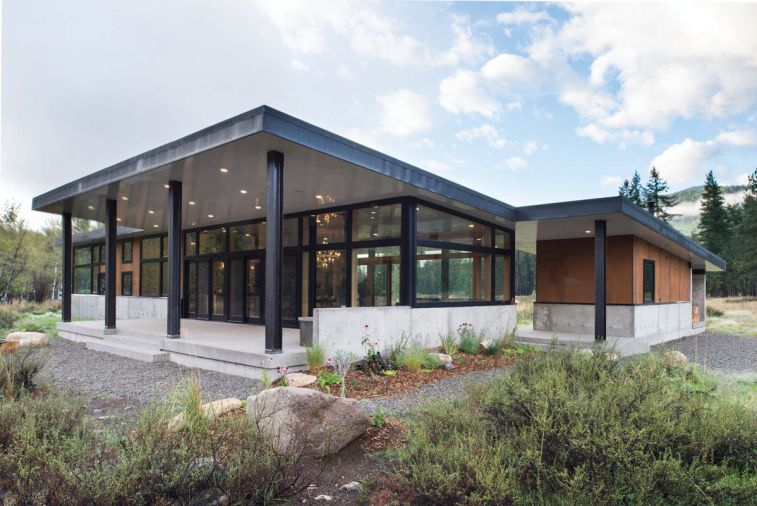 In order to maximize views, better mesh with landscape and grab as much natural light as possible, the architect reduced much of the dwelling to a simple glass box. The home’s windows and sliding glass doors were custom fabricated by Sierra Pacific Windows. The sloped roof allows for normal drainage and retains snow during winter in order to reduce pile-ups around the house and to take advantage of its insulation. The outbuilding, attached only by the veranda’s ceiling, houses the indispensable ski wax room and wood-fired sauna, easily restoked from an adjacent wood box.