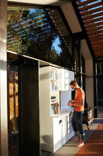 A crisp custom Corian bookcase hides a bar, an electrical outlet and, on its other side, the front door.