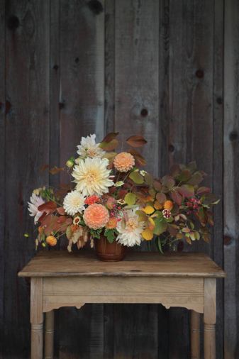 You can assemble this autumnal arrangement designed by Kailla Platt yourself by using these plants and stem count: 6 Dahlia ‘Cafe au Lait,’ 2 Dahlia ‘Crichton Honey,’ 5 Zinnia ‘Persian Carpet,’ 3 Cockscomb Celosia, 3 Northern Sea Oats, 3 Dahlia ‘Ginger Willo,’ 2 Fothergilla foliage, 2 Euonymus europaeus, 3 Heptacodium, 3 Blueberry foliage, 5 Scented Germanium foliage, 2 Viburnum plicatum.