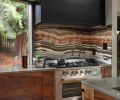 A granite backsplash ties together the tones in the kitchen with the hues seen outside. Drawers by the range provide storage for herbs and spices. Designer and homeowner Christina Tello believes in form following function, which her husband took to heart when he gave her the tree branch salt and pepper shakers.