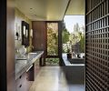 The master bath, which Olson collaborated on with designer Garret Cord Werner, features honed Cambrian black granite countertops with modern, sleek candle sconces. Werner designed the Japanese inspired screen to provide a filter to the walk-in closet.