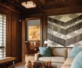 Richer tones and a darker color palette extend to the coffered walnut ceilings and custom lighting designed to aid the homeowner’s sensitivity to light in a bright climate. The inside backs of the wing back chairs in the adjacent living room feature embossed leather. Rasar recommended Romano create large shutters for room-to-room continuity. “We built them as a door with a louvered shutter inside it and carefully aligned the pieces to coordinate with the rest of the paneling,” says Romano.