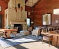The former garage/utilitarian space is now a beautiful retreat, with precious Koa wood walls and wood-saving wainscot that add drama and warmth. A Himmel sectional pairs with a blue area rug by Hokanson. Table lamp by Gregorius Pineo. Large Douglas fir logs were laid on the ground, and then shaped with a motorized hand planer to resemble the sketches that Rod Knipper provided, before wrapping the ends in hemp rope. Mahogany beams are interrupted by ceiling bamboo mats.