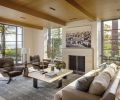 In the living room, a stone chimney rising up into the master bedroom overhead is finished with Marmorino plaster, a flatter finish than Venetian. Interior Designer Amy Baker sets off the Mattaliano sofa with a custom-sized Tibetan rug from Driscoll Robbins, which picks up wisps of blue found in the fresh palette. Art by Phillippe Cognée via Winston Wächter Fine Art.
