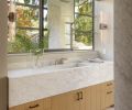 In the master bathroom, Steve Hirt Studio built the tubular sconces. The sliding vanity mirror is by Metal Solutions.