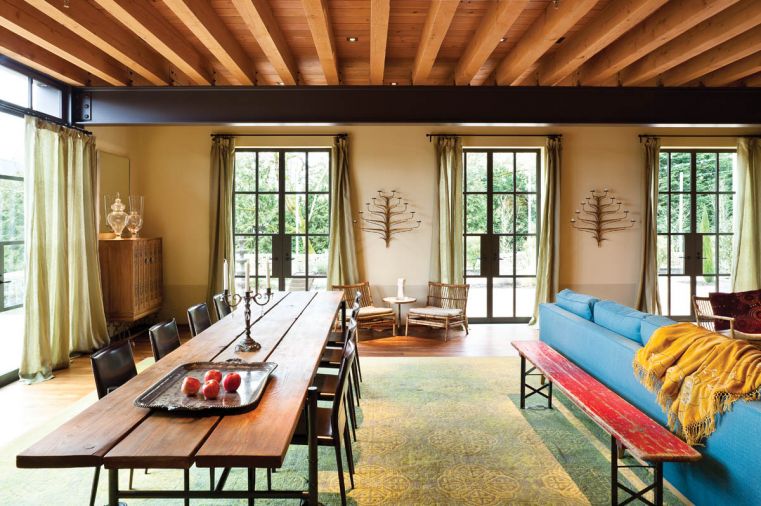 The long dining table in the living room was custom designed by Janice Viekman and fabricated by Decorative Metal Arts. It’s wired to accept vintage table lamps to provide illumination, rather than candles, and it’s mounted on wheels for easy mobility. New Moon Rug was sourced from Driscoll Robbins Fine Carpets.