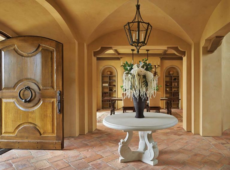 Parefeuille terra cotta tile flooring stretches beyond entry to dining room. To keep with Tuscan home traditions, no baseboards were used.