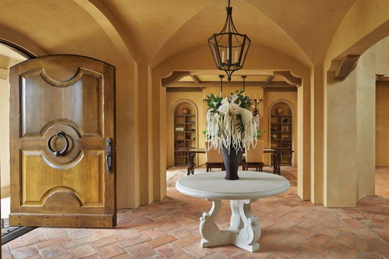 Parefeuille terra cotta tile flooring stretches beyond entry to dining room. To keep with Tuscan home traditions, no baseboards were used.