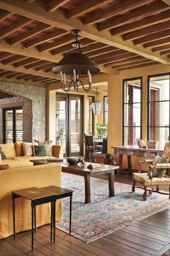 An antique desk and Louis XIV chair face off with a pale gold chenille sofa. The desk is from Dos Gallos in Los Angeles. The hanging fixture is Paul Ferrante.