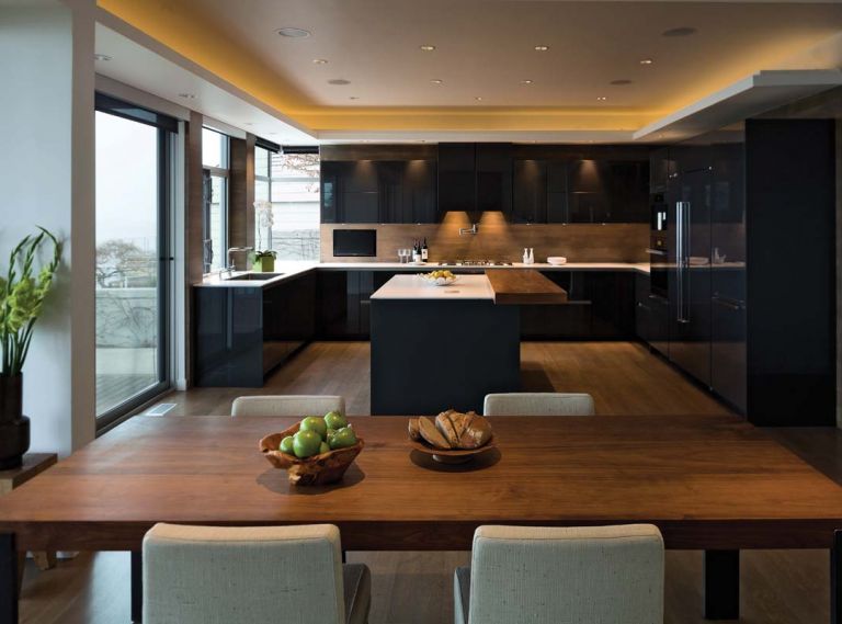 The countertops are made of one-centimeter thick Silestone quartzite. Thin and delicate, the design creates the appearance of a floating white plane, almost weightless, atop a grounding base of graphite grey cabinets. The countertops are sealed with a suede finish to provide a stain-proof, smudge-proof surface. High gloss graphite grey laminate panels are used around the perimeter to clad the fridge, freezer and tall pantry cabinets.