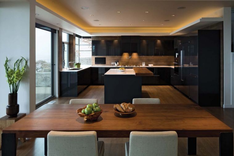 The countertops are made of one-centimeter thick Silestone quartzite. Thin and delicate, the design creates the appearance of a floating white plane, almost weightless, atop a grounding base of graphite grey cabinets. The countertops are sealed with a suede finish to provide a stain-proof, smudge-proof surface. High gloss graphite grey laminate panels are used around the perimeter to clad the fridge, freezer and tall pantry cabinets.
