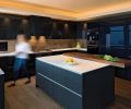 Large appliance storage drawers in the island are equipped with organizational inserts and stainless steel channel handles to keep lines and forms simple and pure. The island is clad in graphite grey matte laminate from SieMatic, which hides fingerprints and is easy to clean. An eight-centimeter thick SieMatic walnut eating bar appears to float above the island, creating a sense of lift as well as warmth.