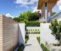 A cedar and concrete wall encloses a private garden.