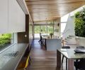 To create an open great room effect, Werner designed one long space inclusive of kitchen, dining and living room, with the kitchen bordered by a living green wall and illuminated by a custom skylight.