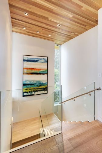 The well-lit staircase rises from the main entry and features the same plank cedar ceiling found on the main floor.