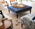 Traditional details like turned wood legs on furniture, a crisp neutral-and-navy color scheme, and preppy, grosgrain-inspired trim on upholstery gives the living room a very classic, comfortable feel.