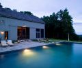 Architect James Dixon of Portland, Oregon, and Chatham, New York, has long had a fascination for barns. 
This one - fashioned as a pool house - looks like a simple vernacular barn when seen from afar, until you get up close
and find it s part of a pavilion.