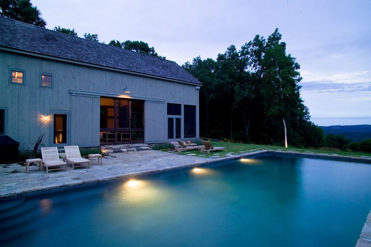 Architect James Dixon of Portland, Oregon, and Chatham, New York, has long had a fascination for barns. 
This one - fashioned as a pool house - looks like a simple vernacular barn when seen from afar, until you get up close
and find it's part of a pavilion.